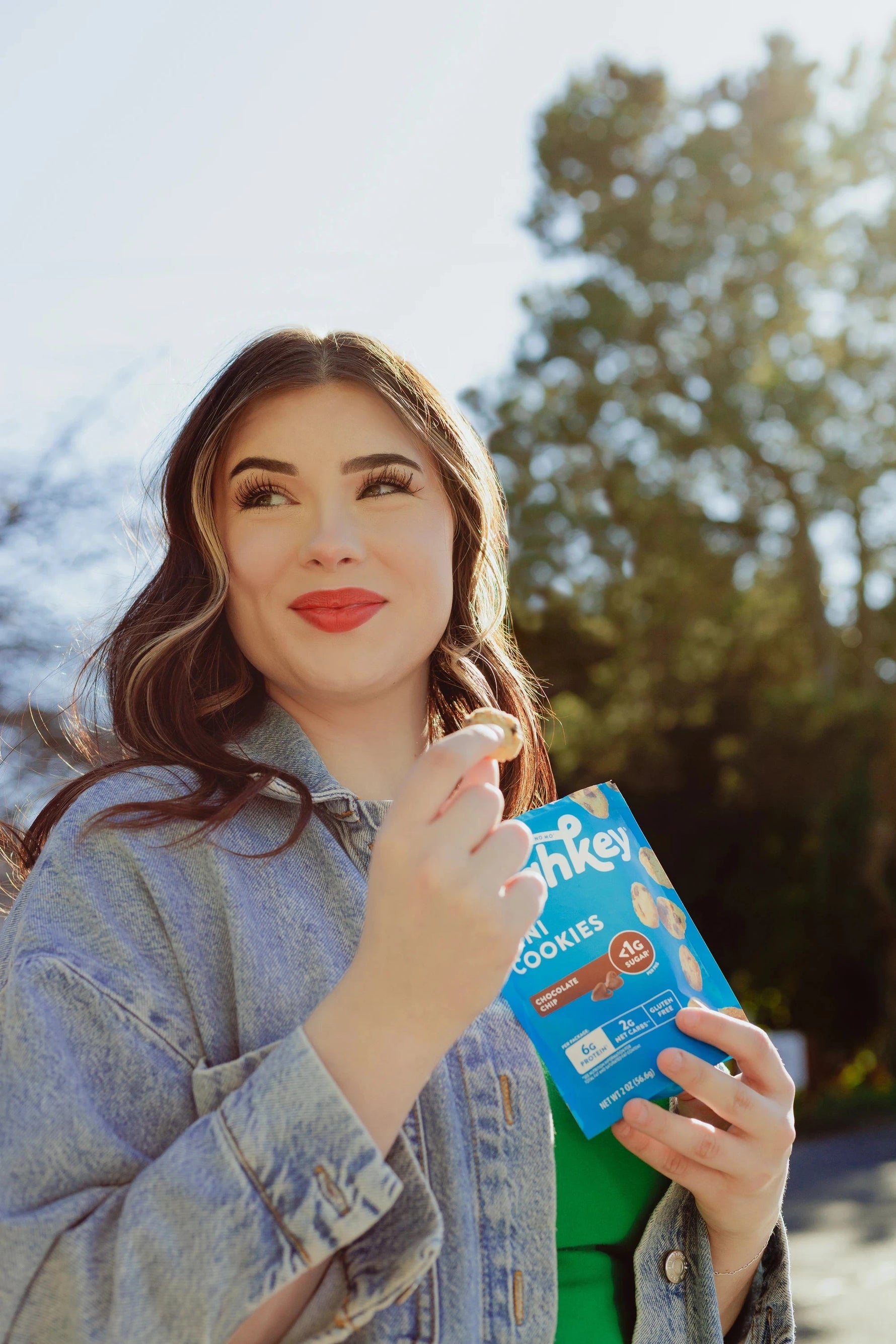 A woman eating highkey gluten free sugar gree snickerdoodle cookies outside